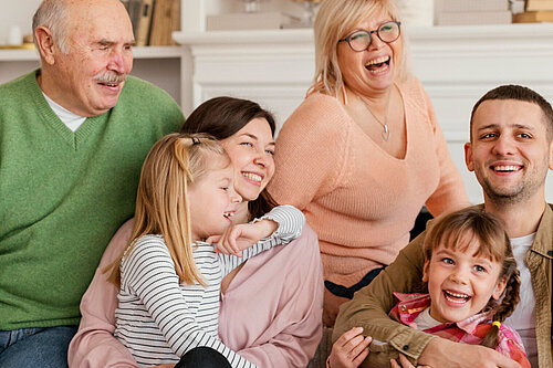 A smiling family with grandparents, parents and children